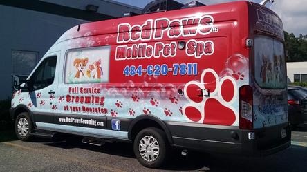Red Paws Mobile Pet Spa grooming van, branded in red with paw prints and the phone number 484-620-7811